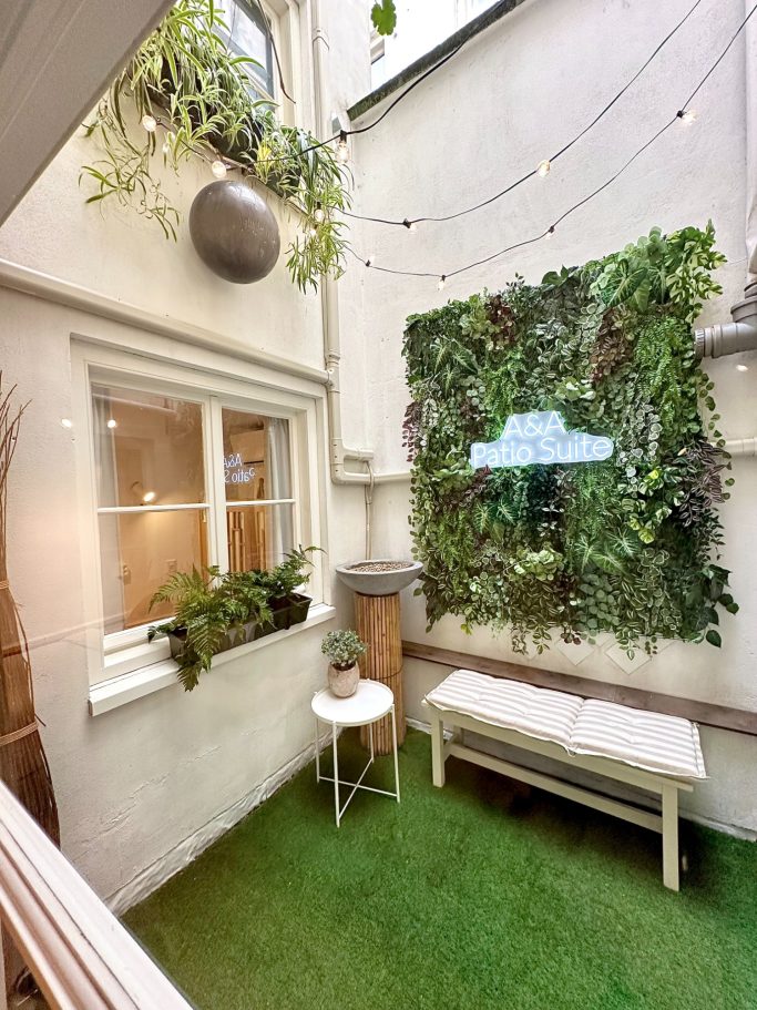 Private Patio Garden A&A PAtio suite patio garden. Een gezellige binnenplaats met planten, een zitbank en sfeervolle verlichting.