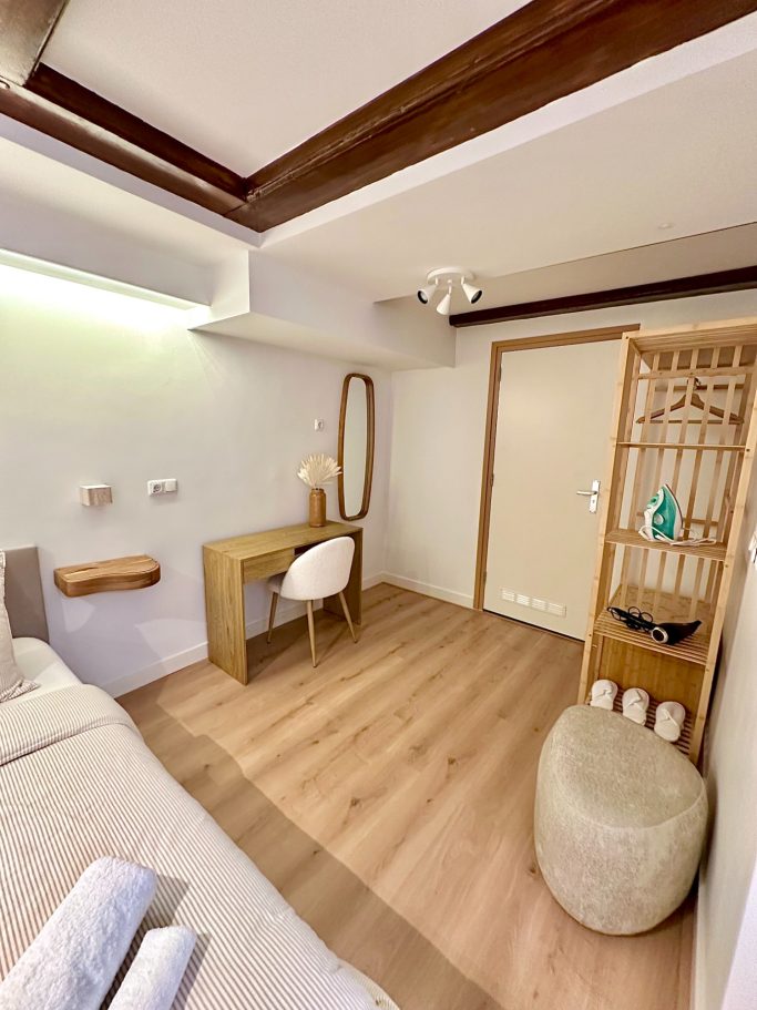 Luxurious Queen Room A&A Patio suite queen room. Moderne slaapkamer met bureau, spiegel en houten elementen, lichte houten vloer.