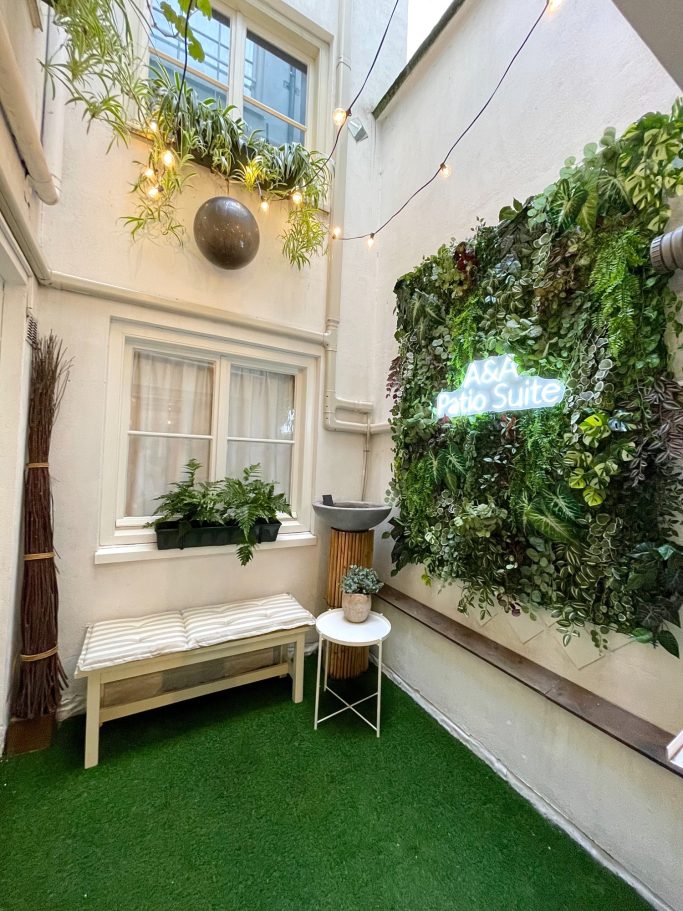Private Patio Garden A&A PAtio suite patio garden. Kleine binnenplaats met groenplanten, een bankje en sfeerverlichting.