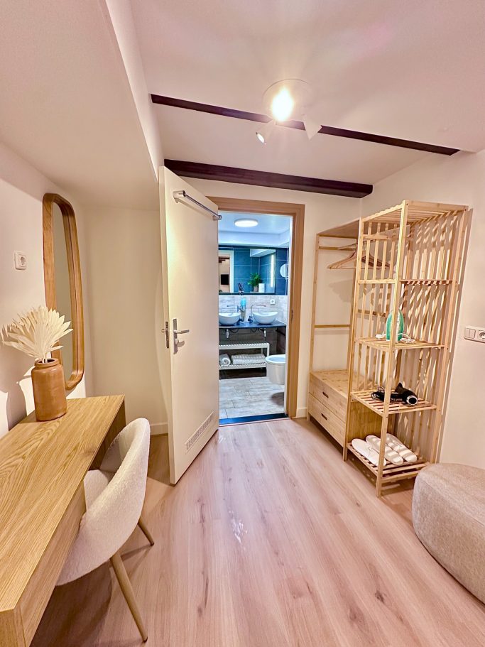 Luxurious Queen Room A&A Patio suite queen room. Interieur van een moderne kamer met een houten bureau, stoel en een open deur naar buiten.